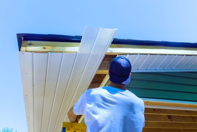 Mounting vinyl soffit plastic boards to roof rafters on ceiling house